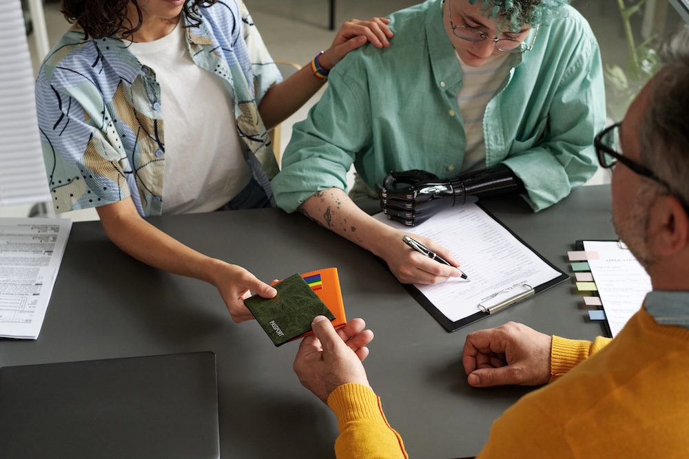 people signing documents in front of a notary
