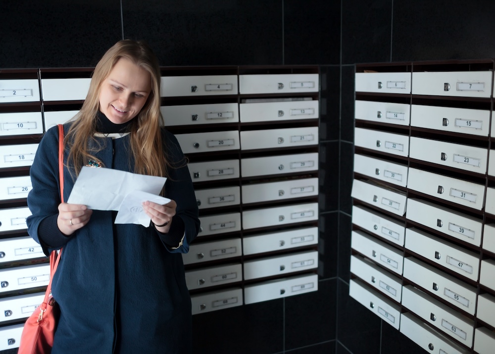 a woman opening mail from her P.O. box